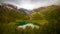 Mystical and marvelous view of the lake in Alps valley between mountains and green trees