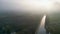 Mystical morning: aerial panoramic view of river, farm field, and forest landscape in morning fog and sunrise