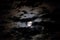 Mystical night sky landscape with white full moon inside of clouds