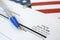 N-400 Application for Naturalization blank form lies on United States flag with blue pen from Department of Homeland Security