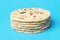 Naan bread isolated on blue background. Stack of indian flatbread