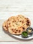naan flatbreads on white wood, copy space, vertical