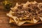 Nacho chips corn garnished with ground beef, melted cheese, jalapeno peppers in plate on wooden table mexican spicy food in mexico