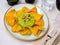 Nachos con guacamole. Corn chips.