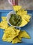 Nachos corn chips with guacamole sauce close up photo