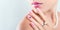 Nail art and design. Beautiful woman wearing make-up and pearl jewellery showing pink manicure with gems. Banner