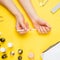 Nail art in the luxurious beauty salon. Gel for modeling nails. A woman receives a manicure by a beautician. On a yellow