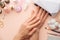 Nail care. beautiful women hands making nails painted with pink gentle nail polish on a pink background. Women`s hands near a set