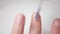 Nail close-up. Use a brush to apply a clear varnish on the nail plate. Applying vitamin enamel to the nail. Manicure