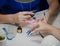 Nail master apply gel polish shellac on a woman hand finger nail stilettos.