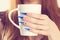 Nail Polish. Modern style new trend blue stilletto Nail Polish. Beauty hands holding white cup with hot beverage tea coffee.