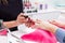 Nail saloon woman painting color nail polish in hands