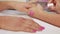 Nail technician applying pink varnish to customers nails