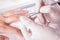 Nail technician giving customer a manicure at nail salon. Young caucasian woman receiving a french manicure. Closeup shot of a