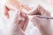 Nail technician giving customer a manicure at nail salon. Young caucasian woman receiving a french manicure. Closeup shot of a