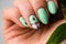 Nails Design. Hands With Bright Green Manicure with flowers. Close Up Of Female Hands. Art Nail