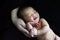 Naked baby newborn have a sweet dream with smile on parent hand.