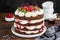 Naked Black forest cake, Schwarzwald pie. Cake with dark chocolate, whipped cream and cherry on a dark wooden background. Copy