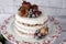 Naked cake with caramelized fruits - strawberries, blueberries, raspberries. Sponge cream cake in floral high plateau, tray