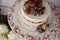 Naked cake with caramelized fruits - strawberries, blueberries, raspberries. Sponge cream cake in floral high plateau, tray