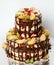 Naked cake with fruit. two-tiered wedding cake with bare vines, tangerine and pomegranate.