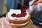 Naked cake hand toping whipped cream berries strawberry cooked birthday wedding homemade