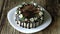 Naked drip cake with chocolate, decorated with strawberries, jasmine flowers and honeysuckle on brown wooden table