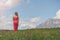 Naked female in a red dress in a field at sunset