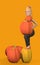 a naked girl in black pants stands with a pumpkin covering her breasts on an orange background 3d-rendering