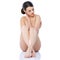 Naked girl sitting isolated with legs crossed