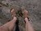 Naked hairy male legs with leather sandals rest while trail