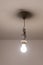 Naked lit light bulb hanging from the ceiling of a dimly lit room