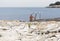 Naked woman bathing in the sea rocky beach with ladder