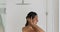 Naked woman standing under the shower washes her hair