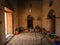 Nakhal, Oman - 04.03.2018: Room of a medieval arabian castle. Carpets and pillow on the floor, holy books on the shelf