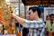 Nakhon Pathom, Thailand: Man Applying Gold Leaf to Buddha