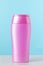 Nameless pink plastic bottle for cosmetic product on a blue background