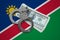 Namibia flag with handcuffs and a bundle of dollars. Currency corruption in the country. Financial crimes