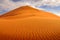 Namibia landscape. Big orange dune with blue sky and clouds, Sossusvlei, Namib desert, Namibia, Southern Africa. Red sand, biggest