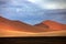 Namibia landscape. Big orange dune with blue sky and clouds, Sossusvlei, Namib desert, Namibia, Southern Africa. Red sand, biggest