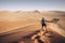 Namibia Namib Desert Sossusvlei Man walking on the top of the famous dunes at sunrise. Epic intrepid adventure travel