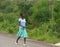 NAMPEVO, MOZAMBIQUE - 7 DECEMBER 2008: Unknown girl African woman dressed in clothes is on the road.