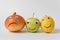 Napiform onion, Apple and lemon with funny faces on white background. Concept of multinational friendship