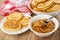 Napkin, bowl with pancakes, pancake with peanut butter in saucer, spoon in bowl with peanut butter on table