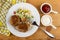 Napkin, fried cutlets with hawaiian blend, fork in plate, sauce boats with ketchup and mayonnaise on table. Top view