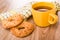 Napkin, shortbread rings with peanut, cup with tea on wooden table