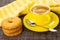Napkin, shortbread rings with sesame, coffee in cup, spoon on saucer on mat