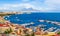 Naples city and port with Mount Vesuvius on the horizon seen from the hills of Posilipo. Seaside landscape of the city harbor and