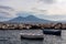 Naples - Two fishermen boats floating in the harbor of Naples, Italy. Panoramic view on volcano Mount Vesuvius