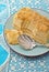 Napoleon cake on a plate on blue tablecloth